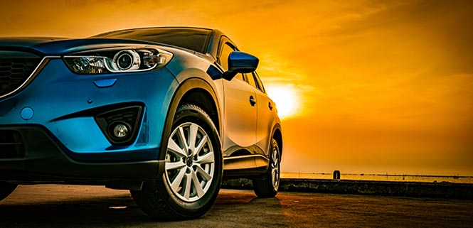 car by the coast at sunset